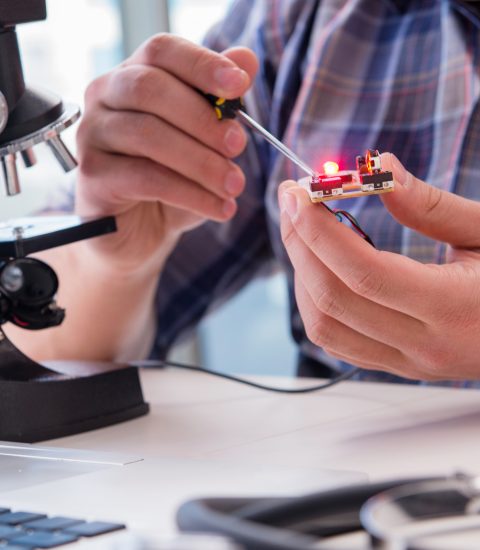High precision engineering with man working with microscope